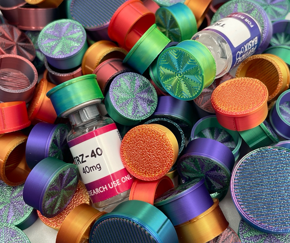 A close-up of various colorful bottle caps in shades of green, purple, orange, and gold scattered around a vial labeled 'Peptide Basix TRZ-40 40 mg' with a 'For Research Use Only' tag.